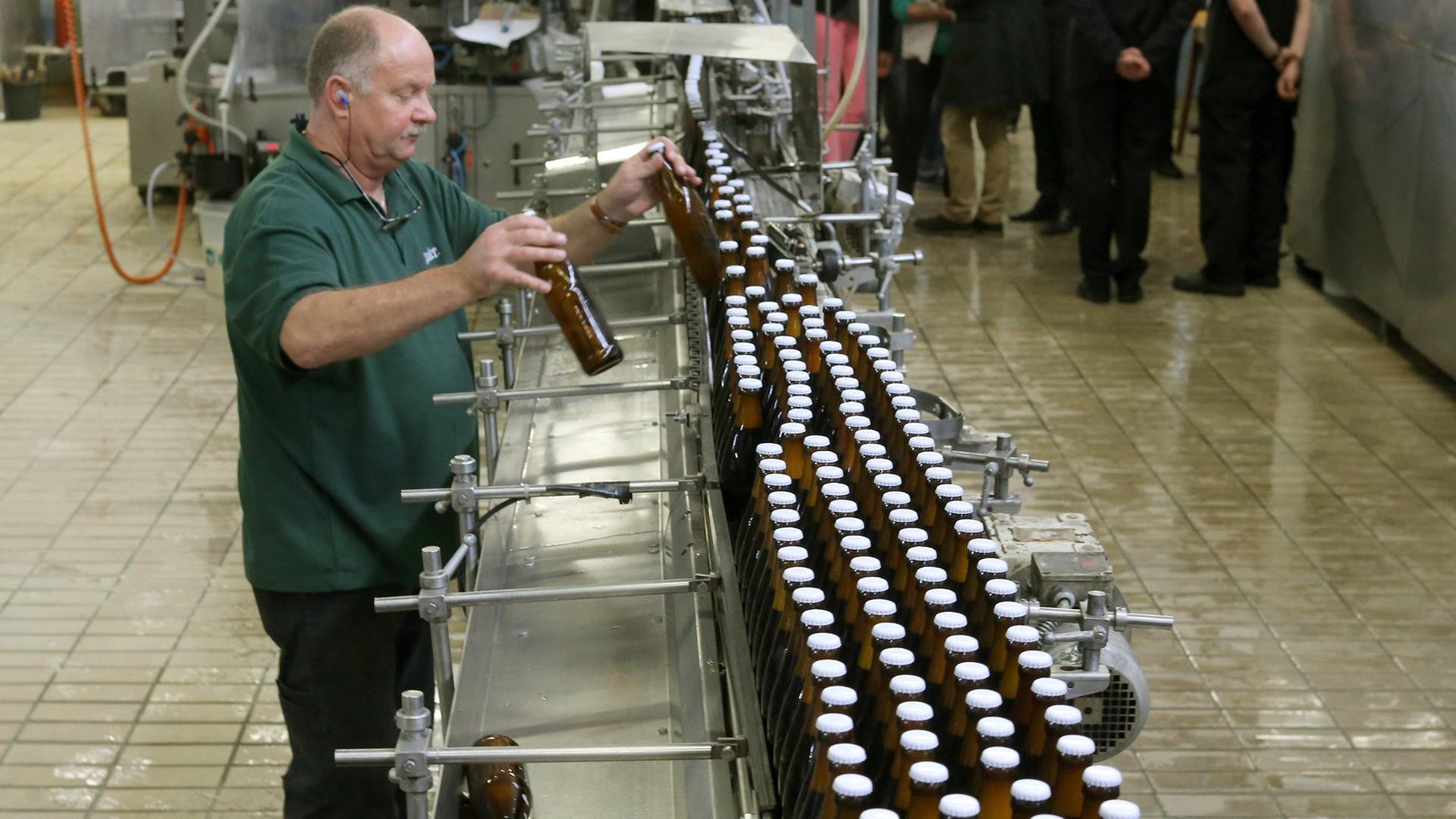 Bierflaschen der Brauerei Stauder laufen über ein Fließband beim Essener Kleberhersteller CPH. Das Unternehmen forscht nach dem richtigen Klebstoff für die Etiketten.