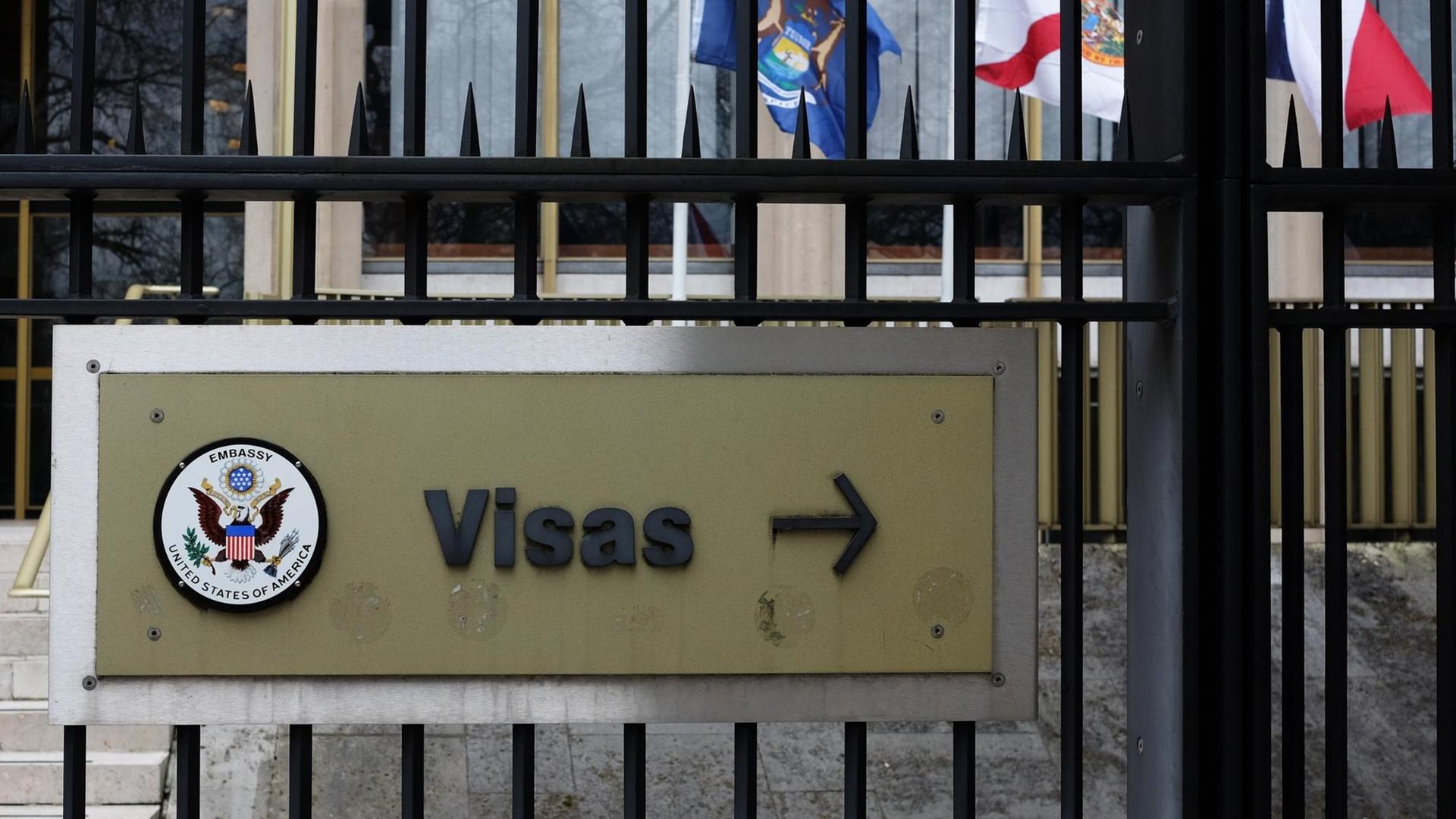 Ein Schild mit der Aufschrift "Visas" und das Große Siegel der Vereinigten Staaten sind an einem Zaun vor dem Gebäude der Botschaft der USA am Grosvenor Square in London angebracht, fotografiert am 17.03.2017 in London (Großbritannien).