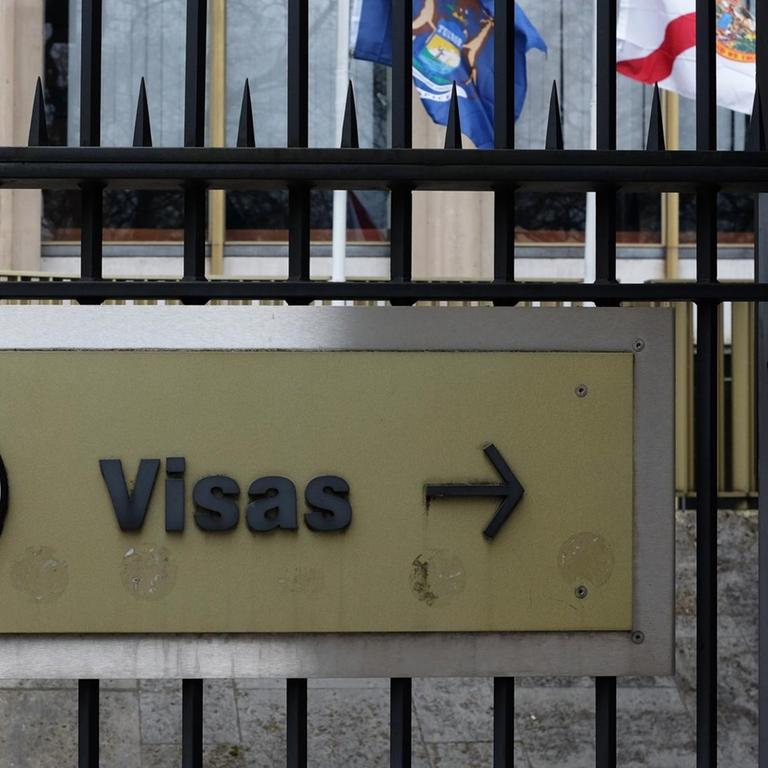 Ein Schild mit der Aufschrift "Visas" und das Große Siegel der Vereinigten Staaten sind an einem Zaun vor dem Gebäude der Botschaft der USA am Grosvenor Square in London angebracht, fotografiert am 17.03.2017 in London (Großbritannien).