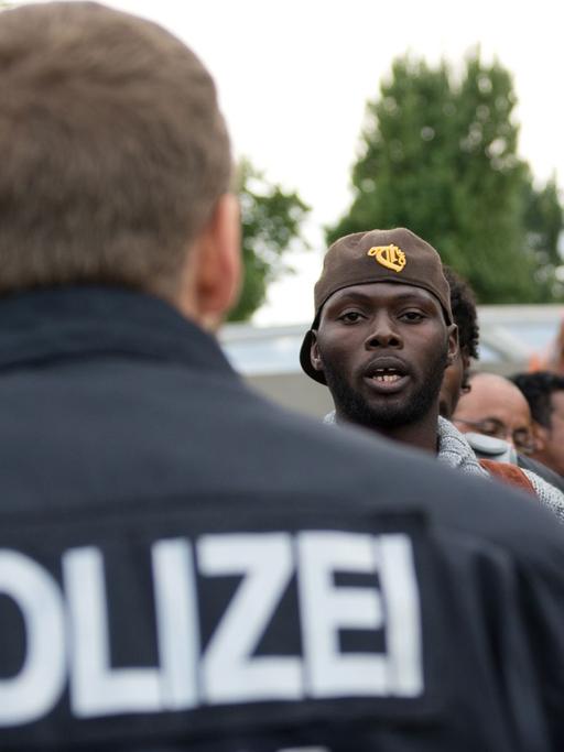 Flüchtlinge diskutieren am 25.8.2014 am besetzten Oranienplatz in Berlin mit Polizisten