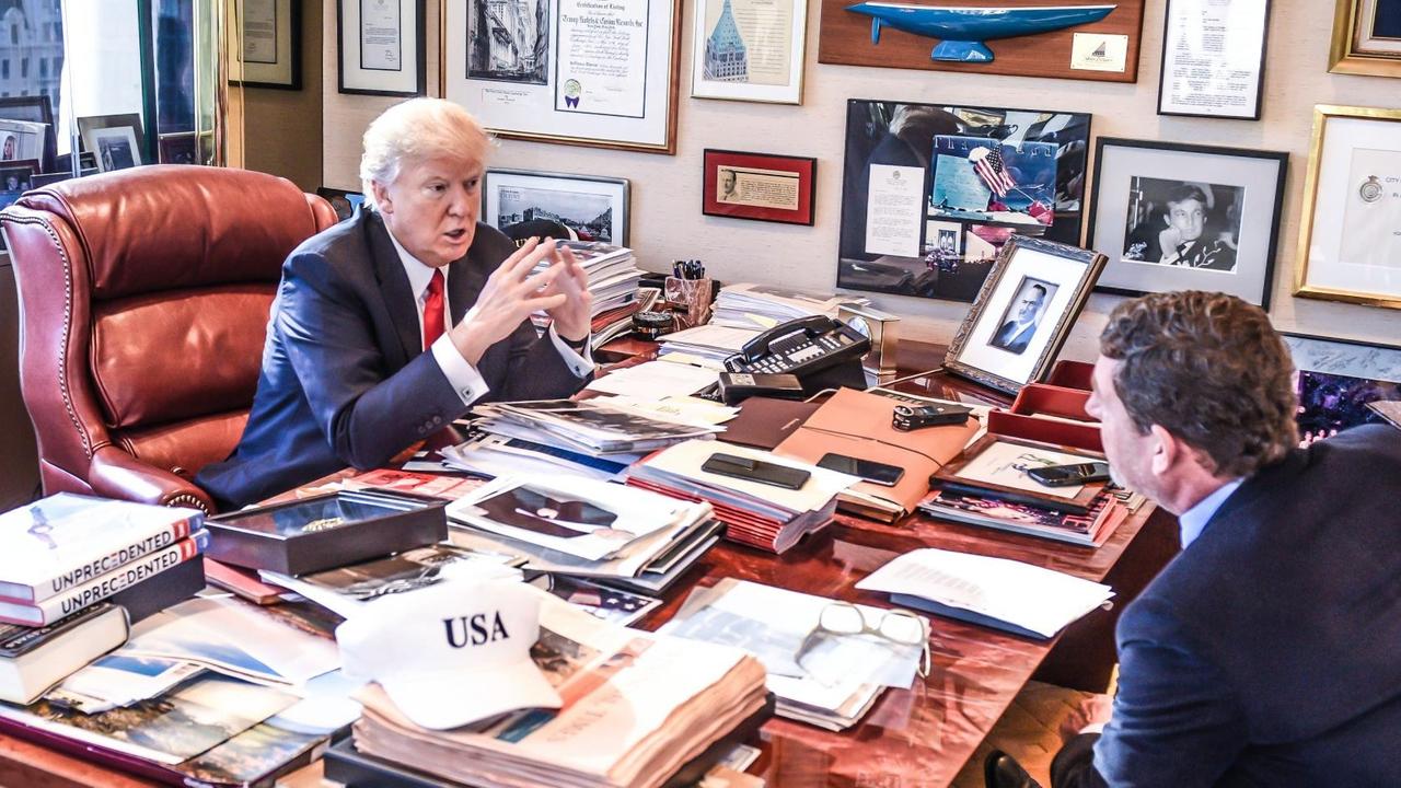 Donald Trump vor seinem vollgestellten Schreibtisch, dahinter Kai Diekmann.