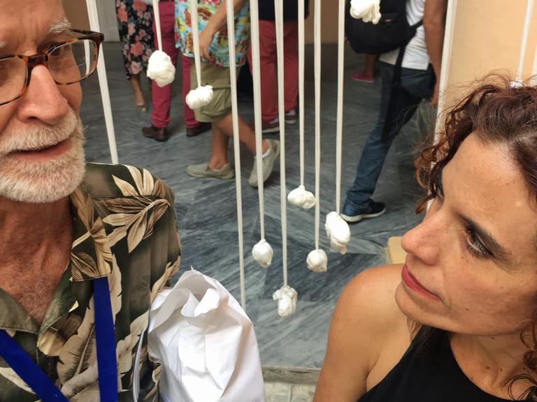 Der Kurator Nelson Herrera Ysla und die Künstlerin Alexia Miranda stehen vor ihrem Kunstwerk "Tejido collectivo".