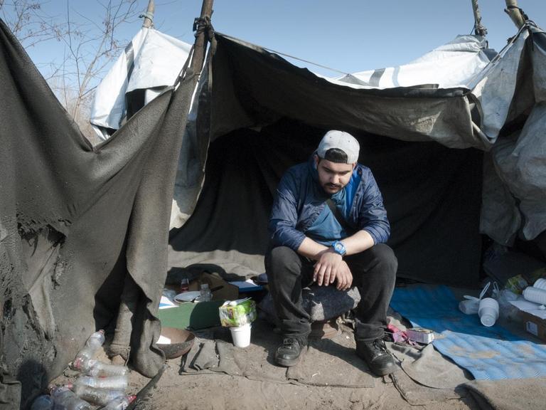 Iraner Amir sitzt in seinem Zelt vor der serbisch-ungarischen Grenze