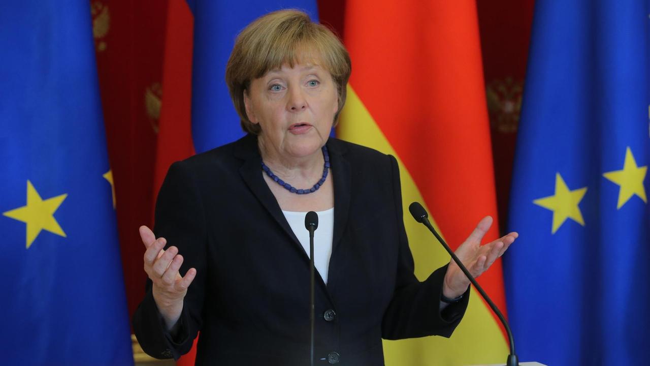 Bundeskanzlerin Angela Merkel steht an einem Rednerpult.
