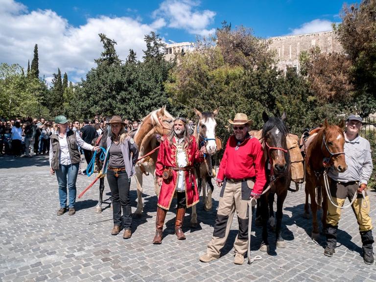 David Wewetzer, Tina Boche, Peter van der Gugten und Zsolt Szabo mit ihren Pferden auf der Dionysiou Areopagitou in Athen.