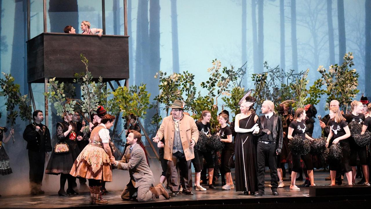 Das Ensemble des Staatstheaters Kassel steht in ländlicher Kleidung auf der Bühne.