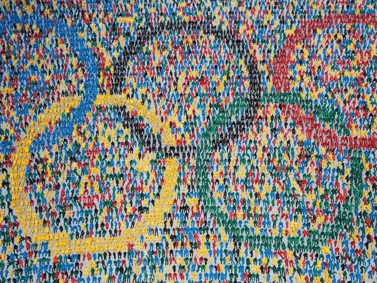 Die olympischen Ringe, zusammengesetzt aus Miniaturfiguren, die auf einer Tribüne sitzen