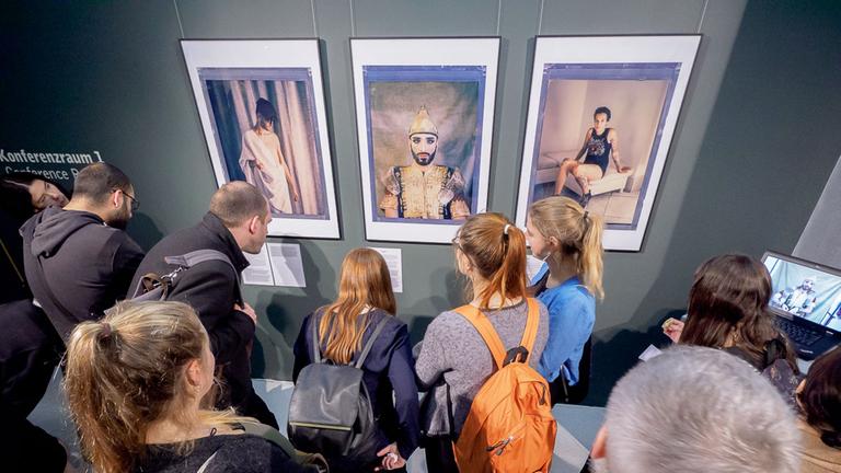 Ausstellungsbesucher vor Porträts des Fotografen Robin Hammond aus seiner Serie "Where love is illegal"