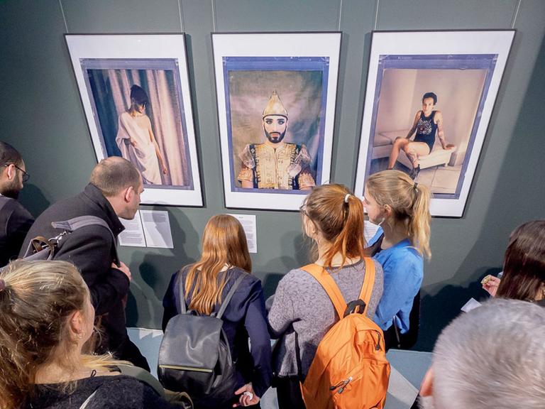 Ausstellungsbesucher vor Porträts des Fotografen Robin Hammond aus seiner Serie "Where love is illegal"