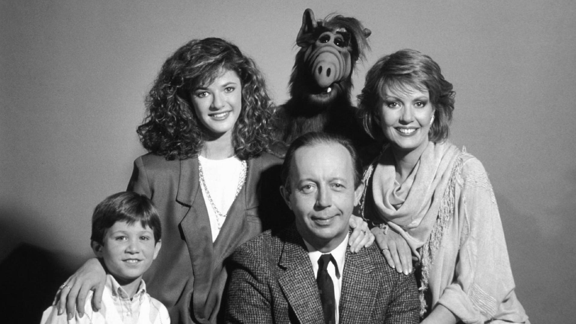 Grupppenbild der Familie mit Alf vor lila-grauem Hintergrund. Grupppenbild der Familie mit Alf vor lila-grauem Hintergrund.