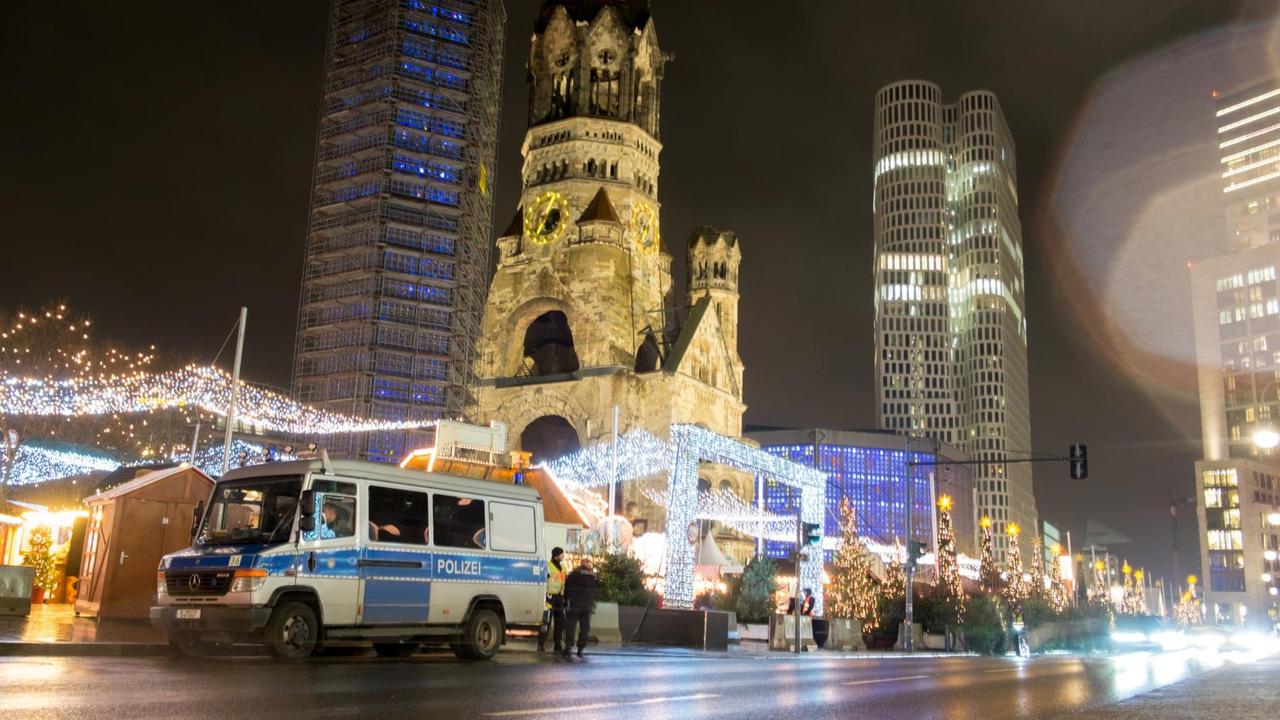 Ein Polizeifahrzeug steht am 14.12.2017 an einem Eingang zum Weihnachtsmarkt am Breitscheidplatz in Berlin. Am 19. Dezember 2016 war der islamistische Attentäter Anis Amri mit einem gestohlenen Laster in den Weihnachtsmarkt an der Gedächtniskirche gerast. Bei dem bislang schwersten islamistischen Anschlag in Deutschland waren zwölf Menschen getötet und annähernd 100 Menschen verletzt worden.