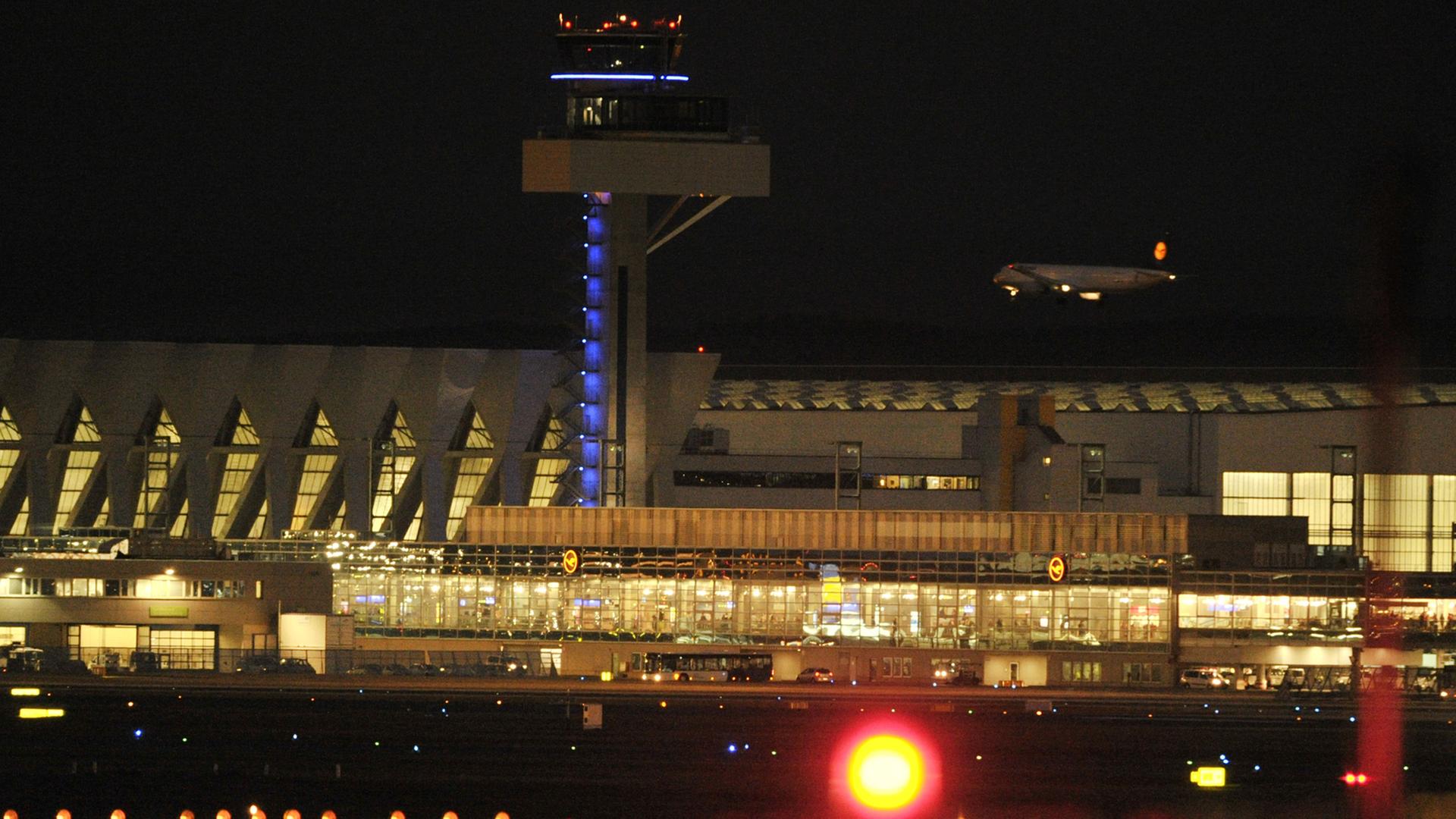 Hinter den Wartungshallen der Lufthansa und dem neuen Tower setzt eine Passagiermaschine am Dienstag auf dem Flughafen von Frankfurt am Main auf der Nordwestbahn zur Landung an.