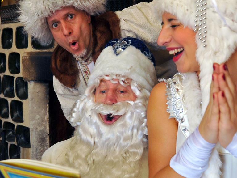 Russische Weihnacht: Väterchen Frost, Iwanuschka und die schöne Wassilissa sitzen in Königstein (Sachsen) vor dem Kamin und lesen.