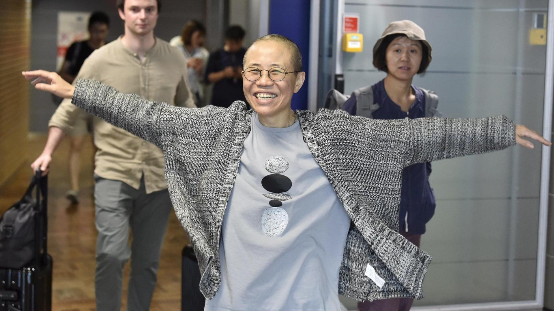 Liu Xia bei ihrer Zwischenlandung in Helsinki hebt vor Freude die Arme in Luft