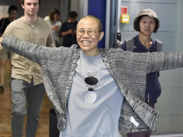 Liu Xia bei ihrer Zwischenlandung in Helsinki hebt vor Freude die Arme in Luft