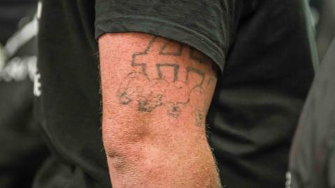 Ein Mitglied von Wodans Erben zeigt ein keltisches Kreuz, das mit weißer Vormachtstellung in Verbindung gebracht wird und in Deutschland als verboten gilt. Die rechtsradikale Gruppe patrouillierte am 12. Oktober durch München