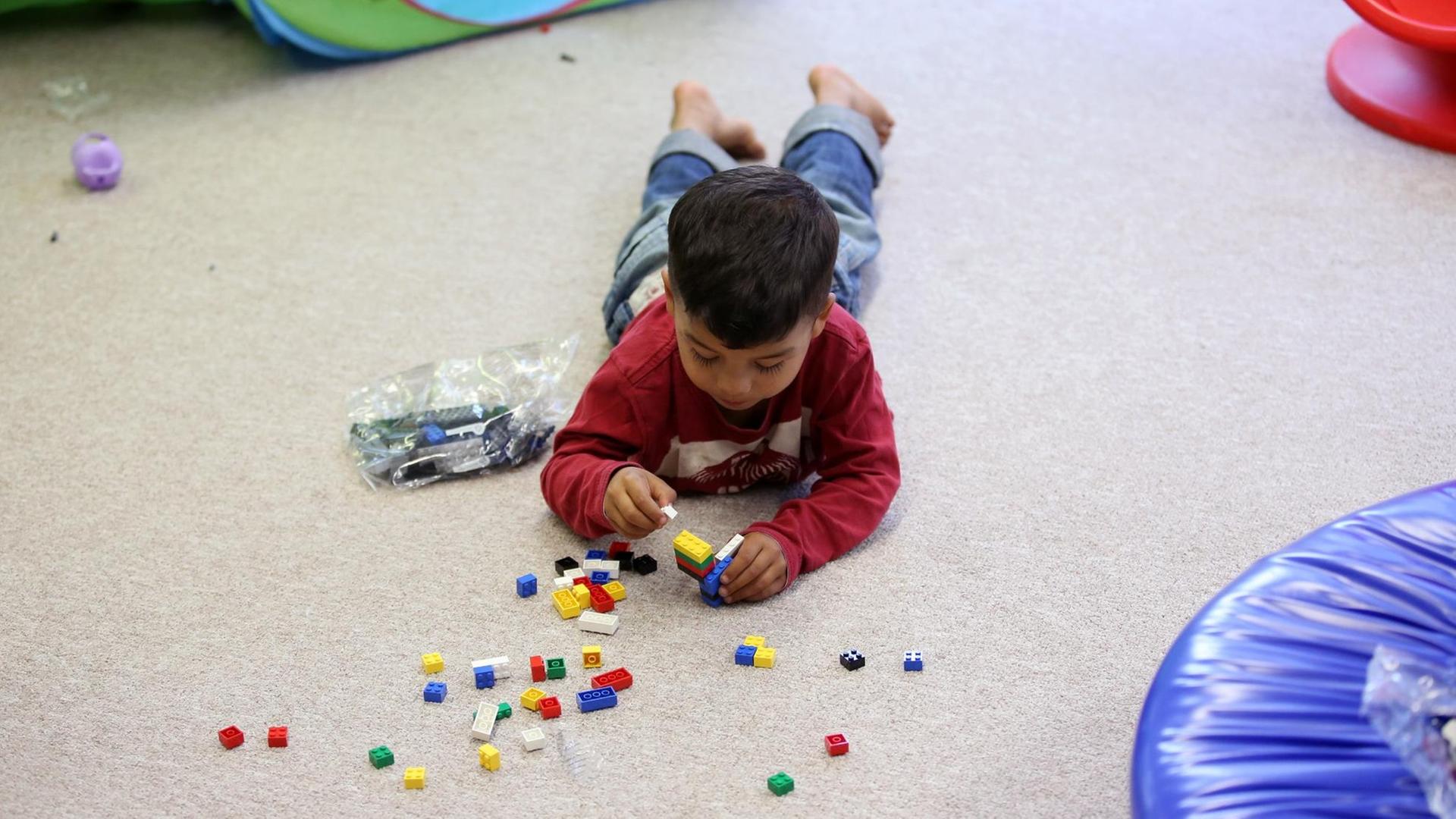 Ein Flüchtlingsjunge spielt im Kindergarten in der Zentralen Erstaufnahme (ZEA) Neuland in Hamburg Harburg mit gespendeten Spielsachen.