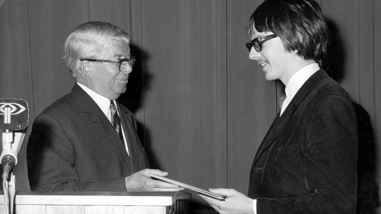 Der österreichische Schriftsteller Peter Handke (r) nimmt am 2. Dezember 1967 aus den Händen von Hermann Gressieker (l) den Gerhard-Hauptmann-Preis der Freien Volksbühne Berlin entgegen.