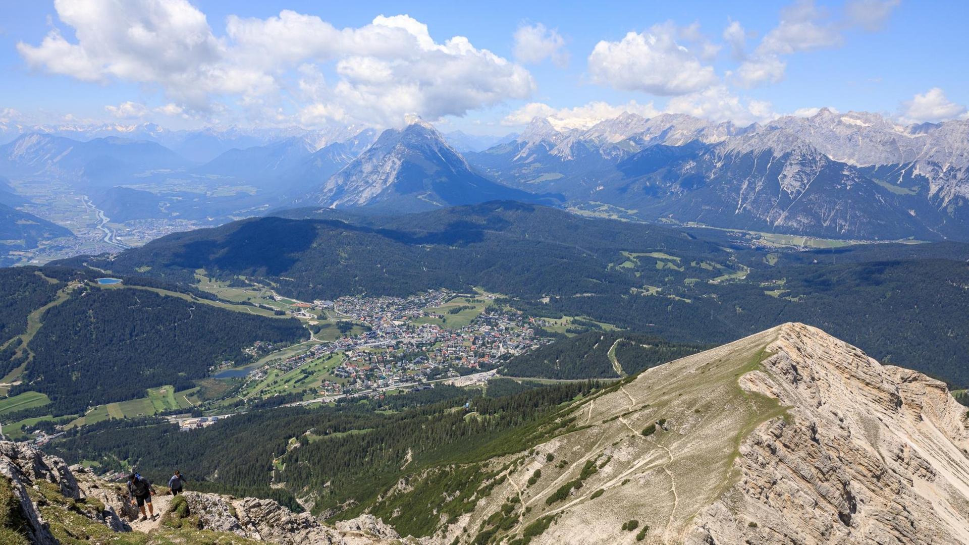 Ausblick von der Reither Spitze auf den Ort Seefeld, die dahinter liegende Hohe Munde bis zum Wettersteingebirge mit Zugspitze