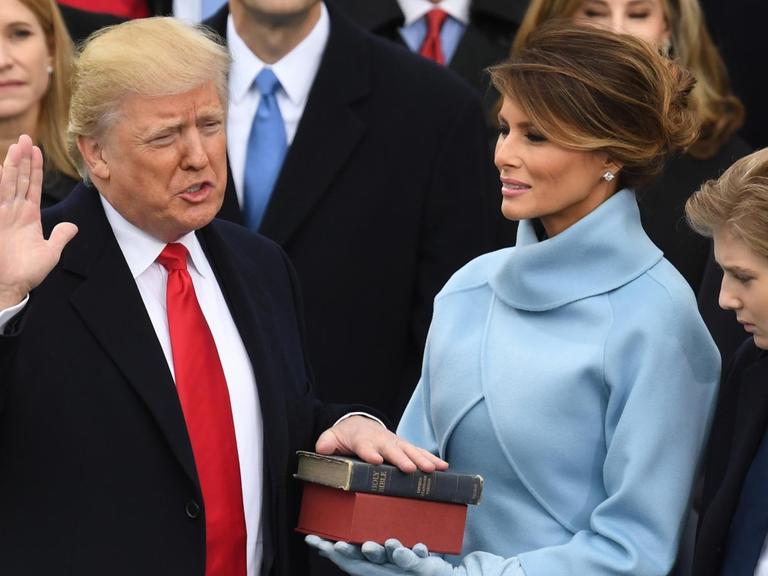 Donald Trump legt den Amtseid als 45. US-Präsident ab. Seine Hand liegt auf der Bibel. Neben ihm steht seine Frau Melania.