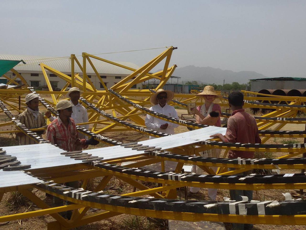 Arbeiter kleben im indischen Ashram Brahma Kumaris Spiegelkacheln auf die Parabelschüsseln des Solarkraftwerks "India One".
