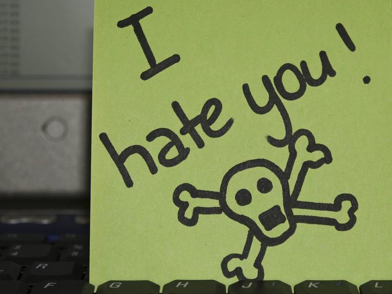 Notizzettel auf Laptop-Tastatur: "I hate you" - Ich hasse dich -, daneben ist ein Totenkopf gezeichnet