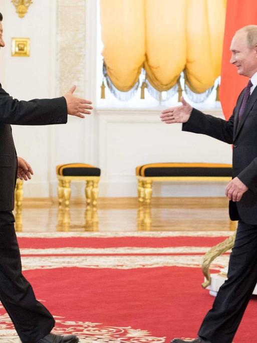 Der chinesische Präsident Xi Jinping schüttelt dem russischen Präsident Vladimir Putin die Hand.