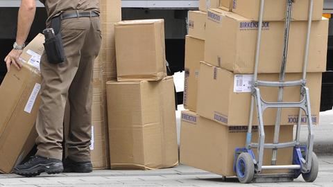 Ein Paketbote sortiert Pakete