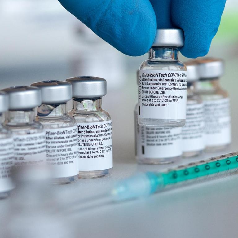 Leere Ampullen des Impfstoffs von Biontech/Pfizer gegen das Corona-Virus SARS-CoV-2 stehen in einem Impfzentrum nach der Vorberietung der Spritzen auf einem Tisch.