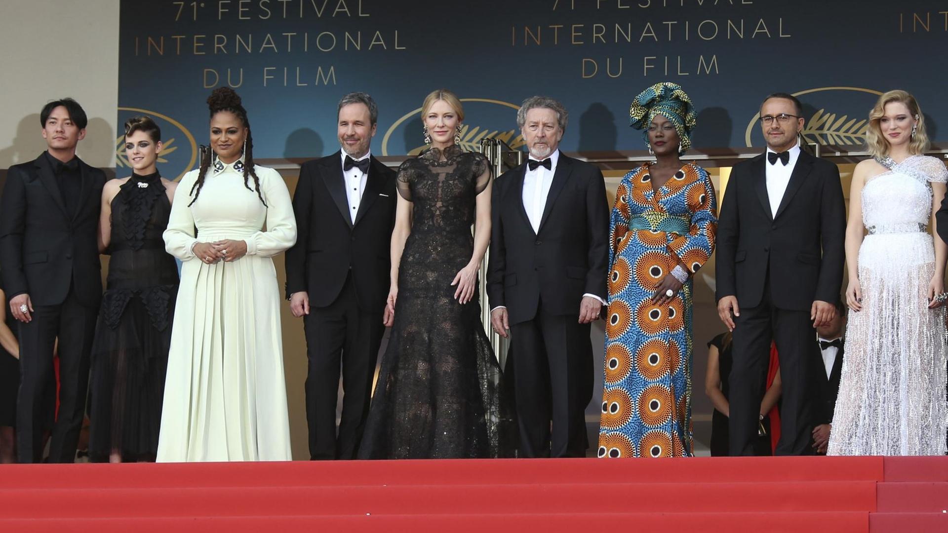 Das Bild zeigt die Jury-Mitglieder in Cannes: Chang Chen, Kristen Stewart, Ava DuVernay, Denis Villeneuve, Cate Blanchett, Robert Guediguian, Khadja Nin, Andrey Zvyagintsev und Lea Seydoux auf dem roten Teppich.