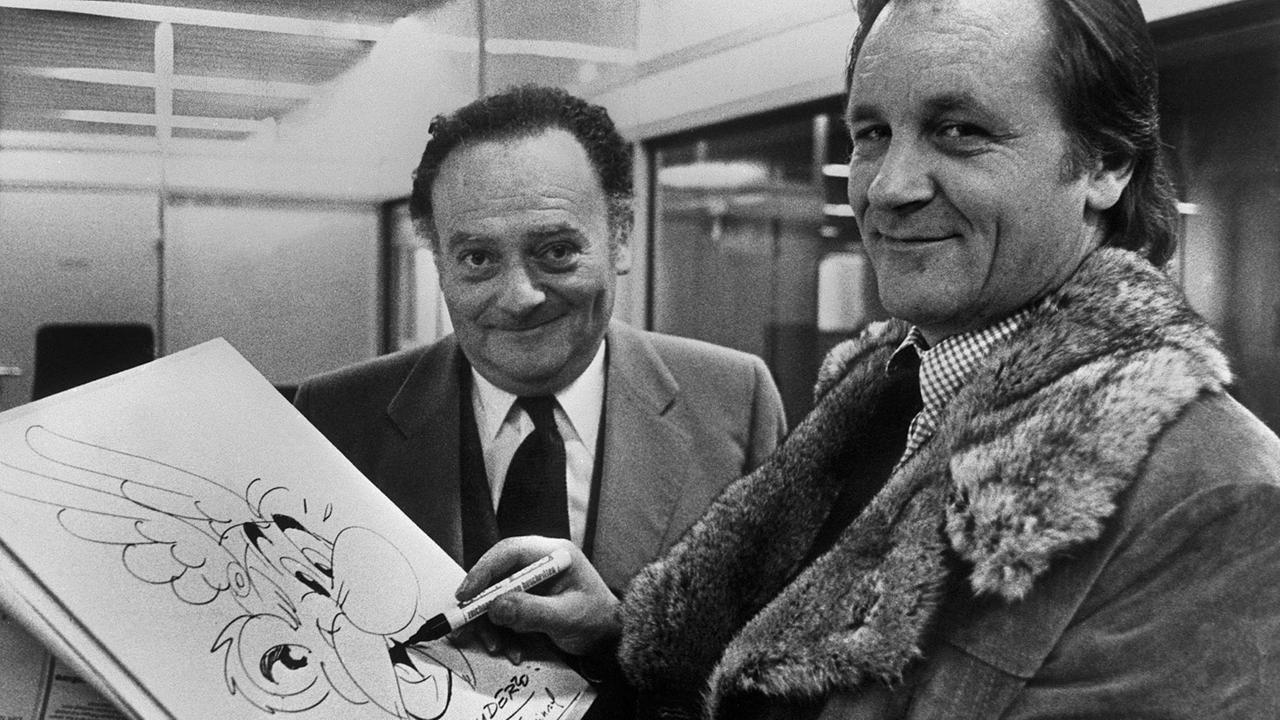 Ein Foto aus den 1970er Jahren zeigt  Albert Uderzo (r) and René Goscinny (l) mit einer Zeichnung ihres berühmt gewordenen Charakters Asterix. 