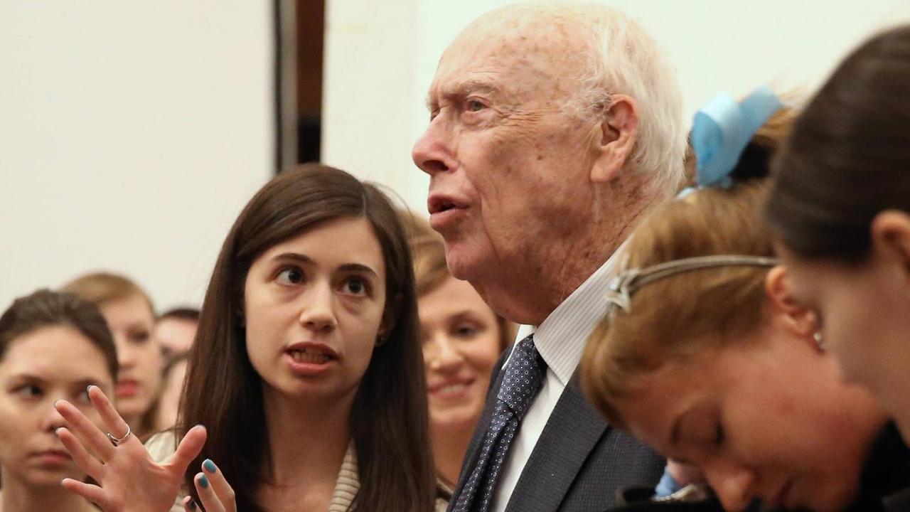 Der Nobelpreisträger James Watson im Jahr 2015, umringt von mehreren Personen.