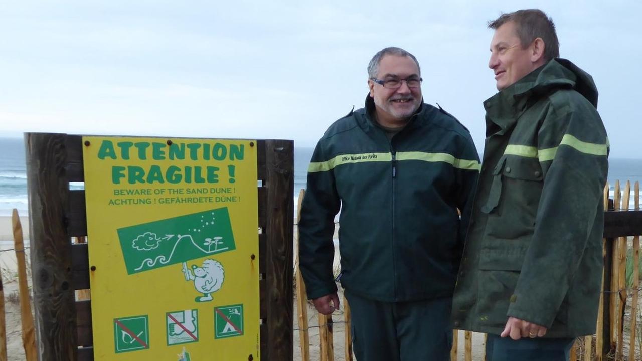 Francis Maugard und Frédéric Kaminski von der staatlichen Forstbehörde entscheiden jedes Jahr neu, wie Millionen Urlauber zum Strand geleitet werden können, ohne die Dünen zu beschädigen.