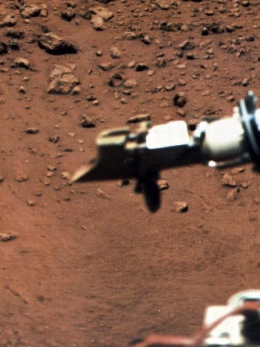 Am 15. August 1976 wurde diese Aufnahme der Oberfläche des roten Planeten Mars von der Raumsonde "Viking" aufgenommen. Vorne links an einem Ausleger eine Magnet-Bürste, rechts der Behälter eines meteorologischen Instruments, das kurz nach der Landung in Betrieb genommen wurde.