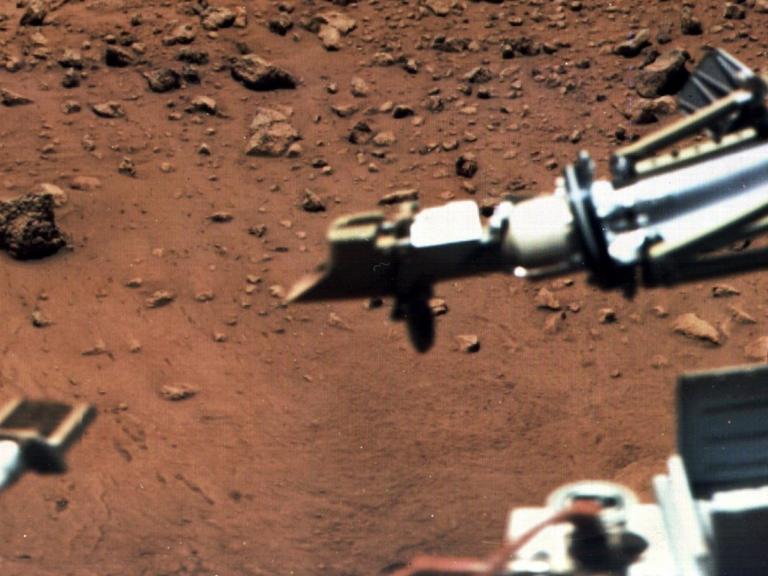 Am 15. August 1976 wurde diese Aufnahme der Oberfläche des roten Planeten Mars von der Raumsonde "Viking" aufgenommen. Vorne links an einem Ausleger eine Magnet-Bürste, rechts der Behälter eines meteorologischen Instruments, das kurz nach der Landung in Betrieb genommen wurde.