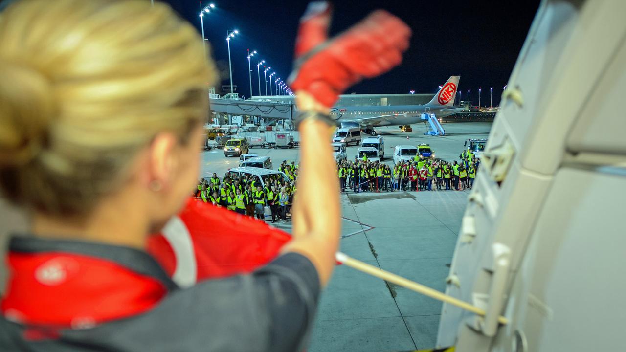 Eine Flugbegleiterin der Fluggesellschaft Air Berlin winkt am 27. Oktober 2017 auf dem Flughafen in München weiteren Mitarbeitern der Airline vor dem letzten Flug zur Verabschiedung.