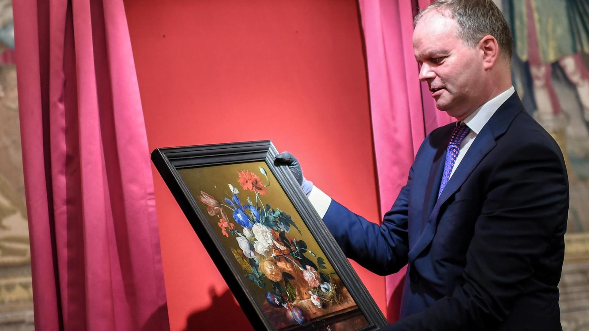 Eike Dieter Schmidt, Direktor der Uffizien, hängt ein Gemälde an seinen Platz.
