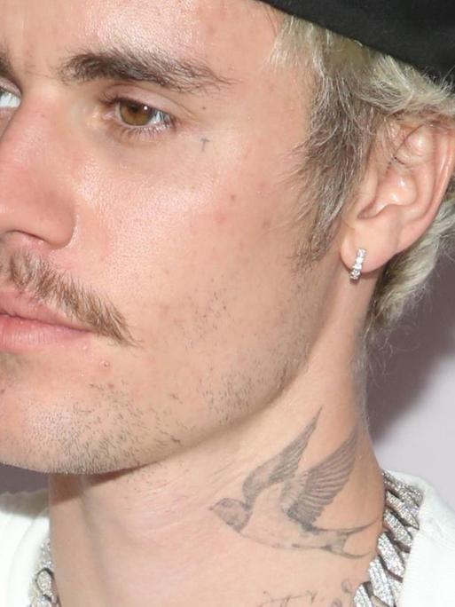 Porträtfoto des Musikers Justin Bieber am 27. Januar 2020 in Kalifornien bei der Premiere der Youtube-Doku "Seasons": mit nach hinten gedrehter Basecap und dicker silberfarbener Kette.