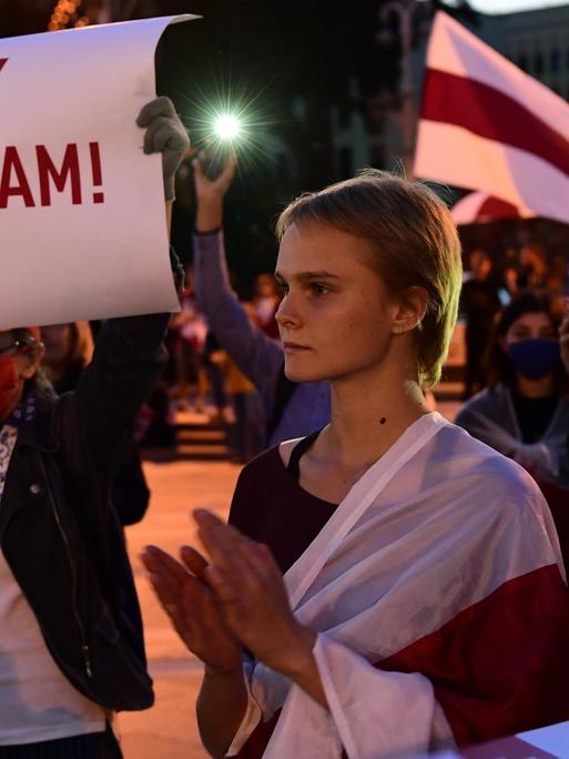 Mehrere Demonstrantinnen und Demonstranten, eine Frau hält ein Schilder in die Höhe, auf dem steht: "Gebt Journalisten Freiheit"