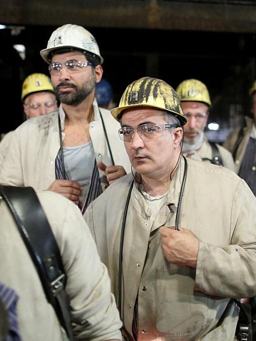 Bergleute in Arbeitskleidung und mit Helmen.