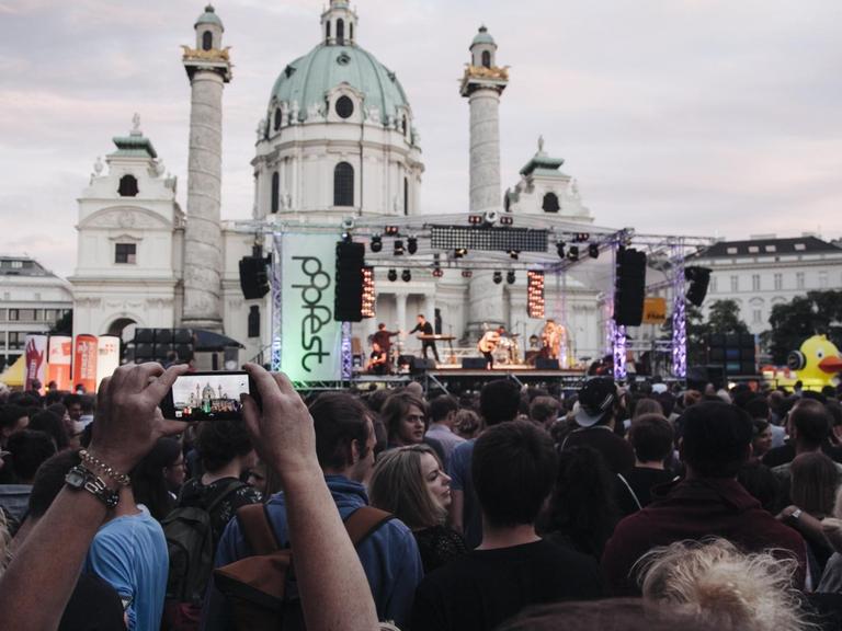 Besucher drängen sich vor der Bühne des popfests an der Wiener Karlskirche