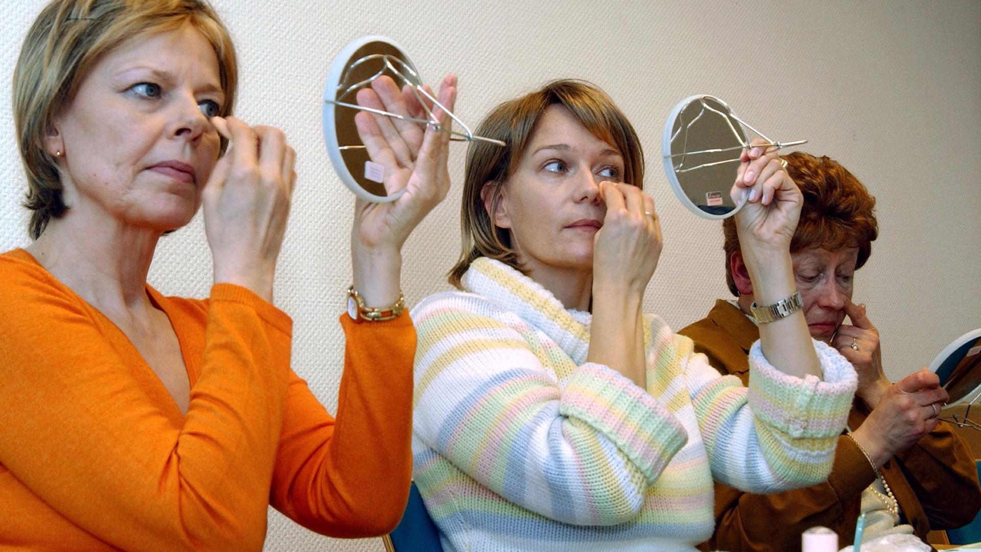 An Krebs erkrankte Patientinnen schminken sich während des Kurses "Freude am Leben" im St.-Johannes-Hospital in Dortmund (Foto vom 16.02.2005). Infolge der Krankheit und der Behandlung durch Strahlen- oder Chemotherapie fallen bei vielen Betroffenen die Haare aus, die Haut verändert sich und wird empfindlicher. Make-up und die richtigen Schminktipps sollen den Frauen helfen, sich schön zu fühlen und "Freude am Leben" zurückzugewinnen.