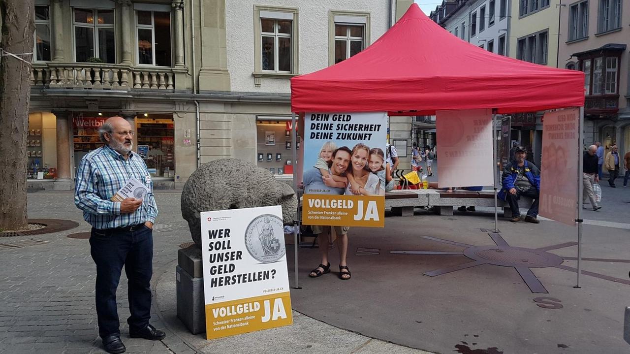 Info-Stand der Schweizer Vollgeld-Initiative am Bärenplatz in St. Gallen. Reinhold Harringer (links) hält einen Stapel Broschüren in der Hand. Aufnahme vom 02.06.2018
