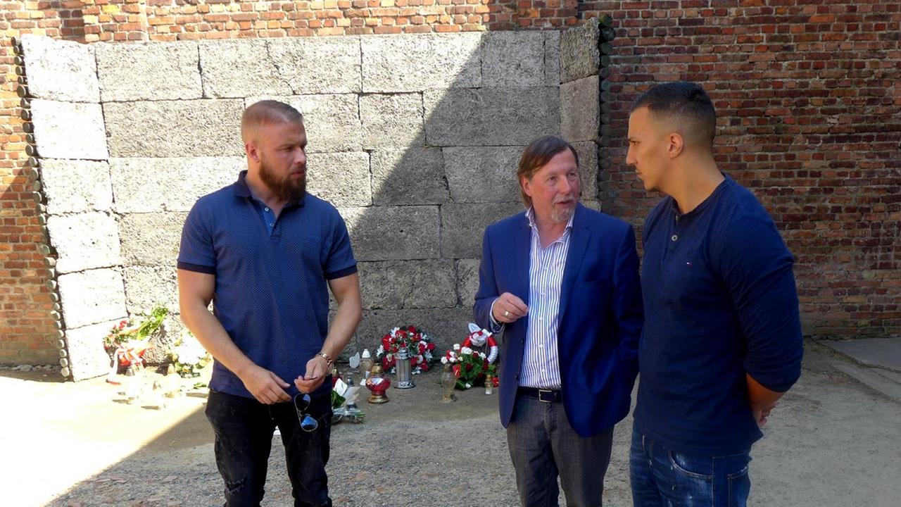 Der Vizepräsident des Internationalen Auschwitz Komitees, Heumbner (Mitte), steht mit den Rappern Kollegah (links) und Farid Bang an der Todeswand in der KZ-Gedenkstätte Auschwitz.