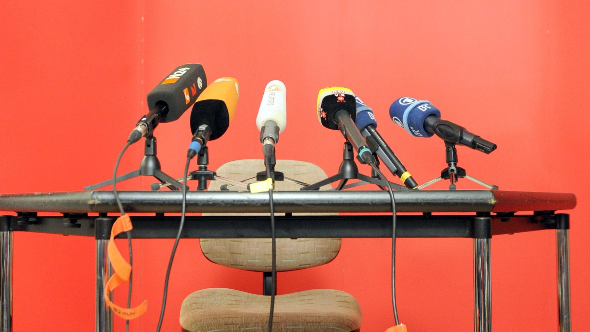 Mehrere Mikrofone stehen auf einem Tisch.