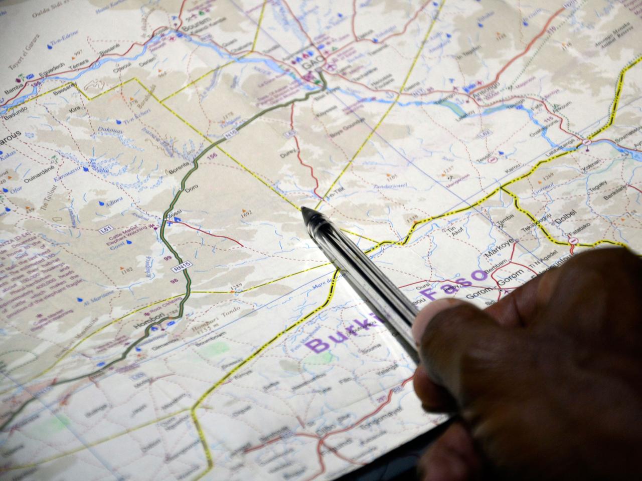 Ein Offizieller zeigt mit der Spitze eines Kugelschreibers die Stelle auf einer Landkarte, an der die vermisste Air-Algérie-Maschine abgestürzt sein soll.