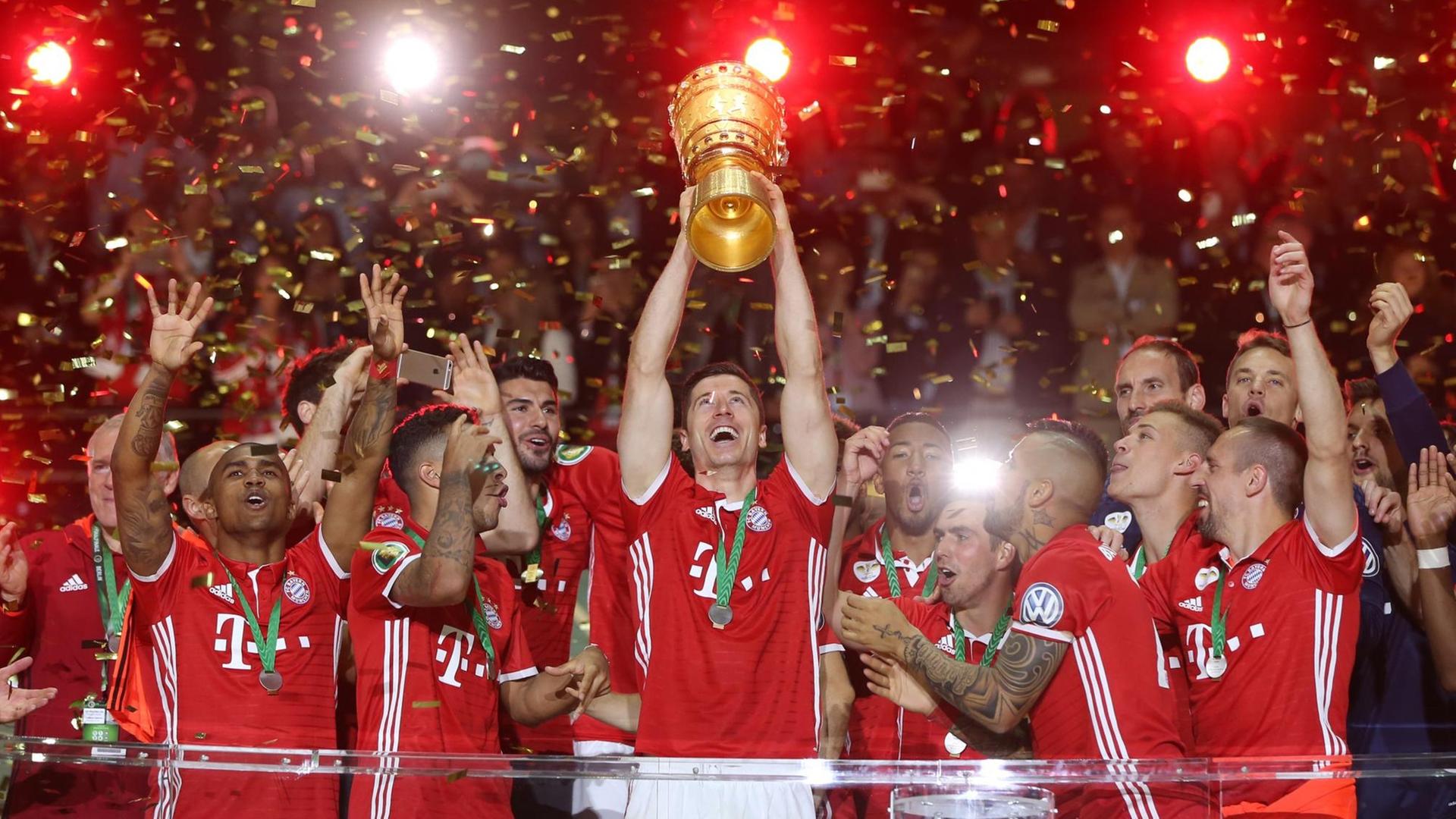 Stürmer Robert Lewandowski hält, umringt von der restlichen Mannschaft Bayern Münchens, den DFB-Pokal in die Höhe.