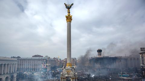 Der Maidan-Platz in Kiew. Verbranntes Material und Trümer liegen überall herum, Rauchschwaden sind zu sehen.
