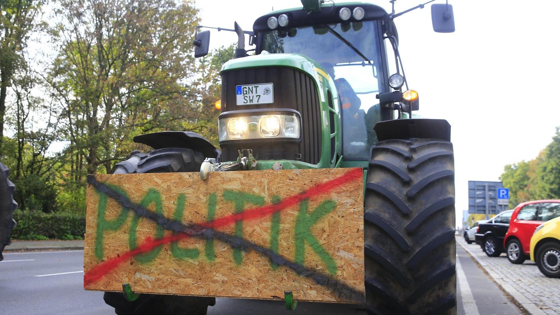 Bauernproteste in Berlin am 22. Oktober 2019. Ein Traktor ist mit einem Schild versehen. Darauf steht das Wort Politik, das durchgestrichen ist.