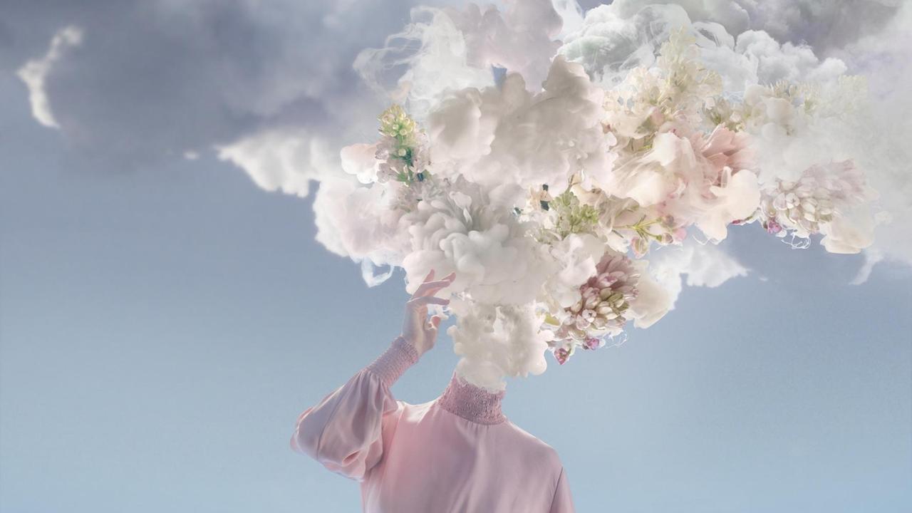 Eine Frau im rosa Kleid, die anstelle eine Kopfes eine Wolke mit pastellfarbenen Blüten auf ihrem Hals sitzen hat.